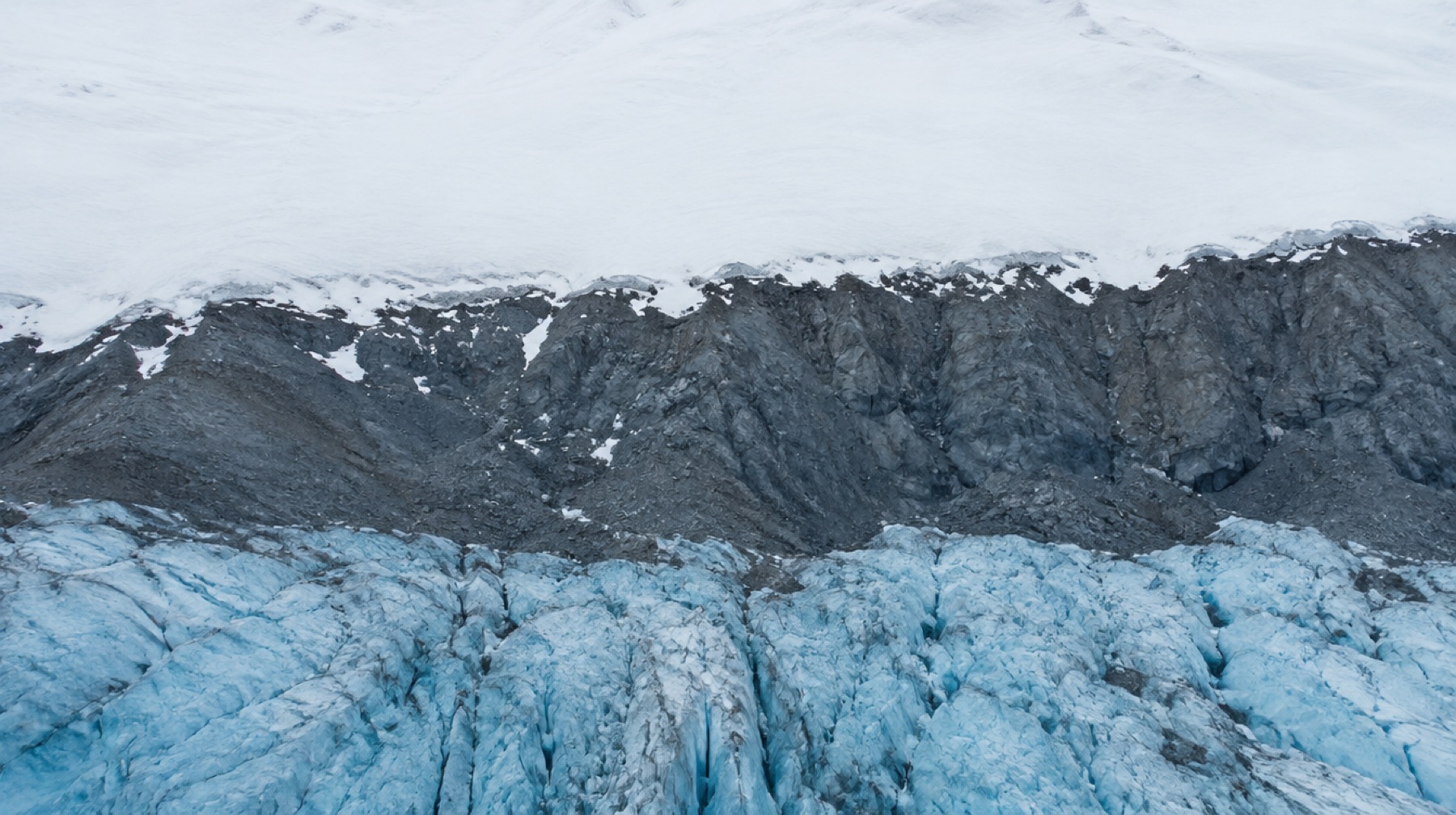 A glacier beneath a broad snowfield